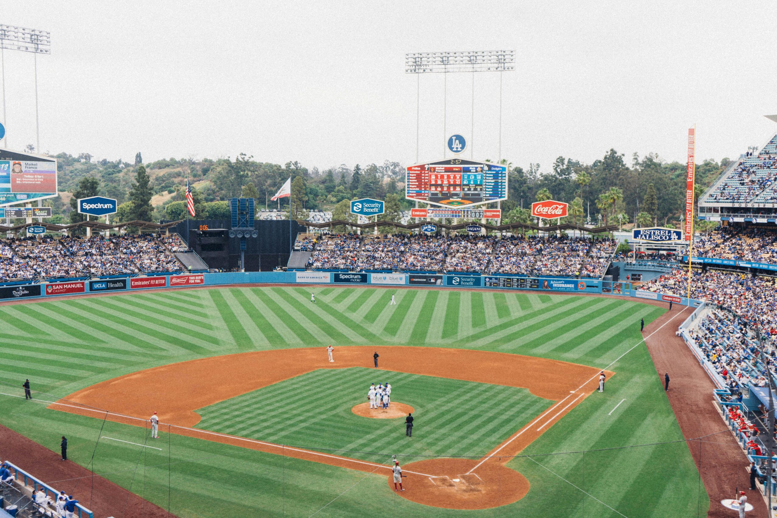 Vibrant baseball game at Dodger Stadium with packed stands and players on the field.