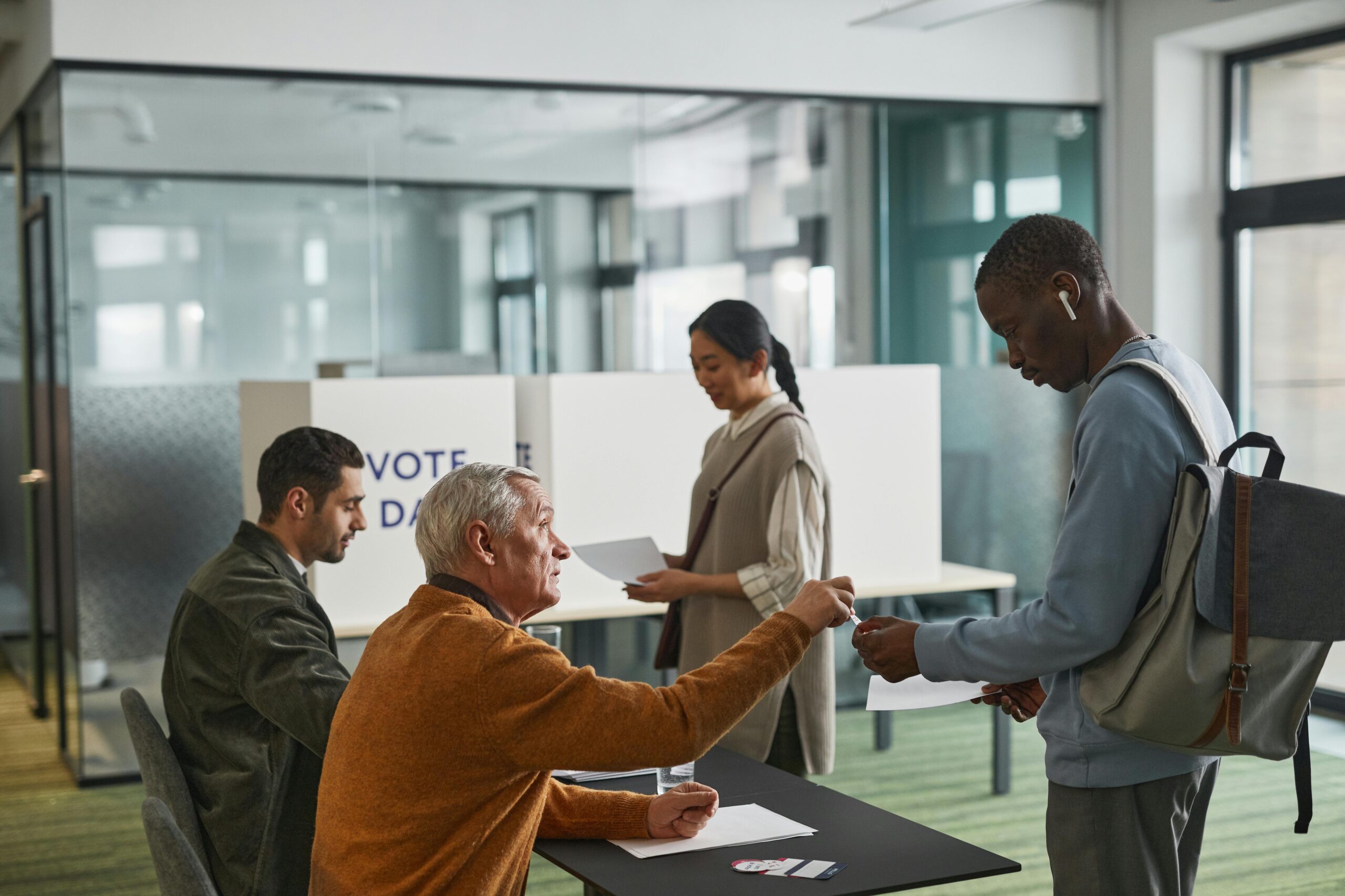 People of various backgrounds participating in voting at a polling station.